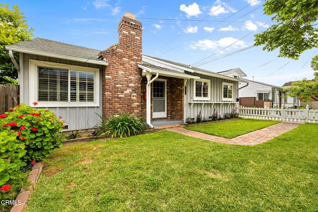 view of front of property with fence, a chimney, and board and batten siding