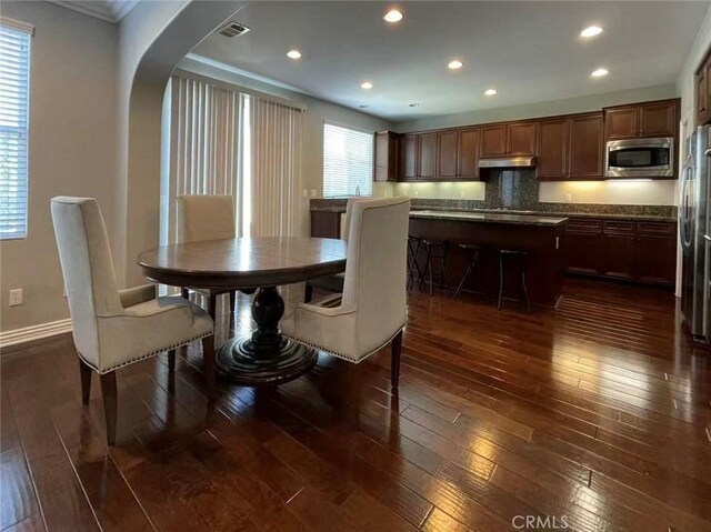 1027 Palmetto Way, Costa Mesa, CA 92626 - dining room featuring visible vents, crown molding, arched walkways, baseboards, and dark wood-type flooring