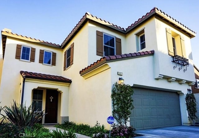 1027 Palmetto Way, Costa Mesa, CA 92626 - mediterranean / spanish-style home with concrete driveway, a tiled roof, an attached garage, and stucco siding