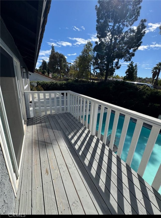 wooden deck with a fenced in pool