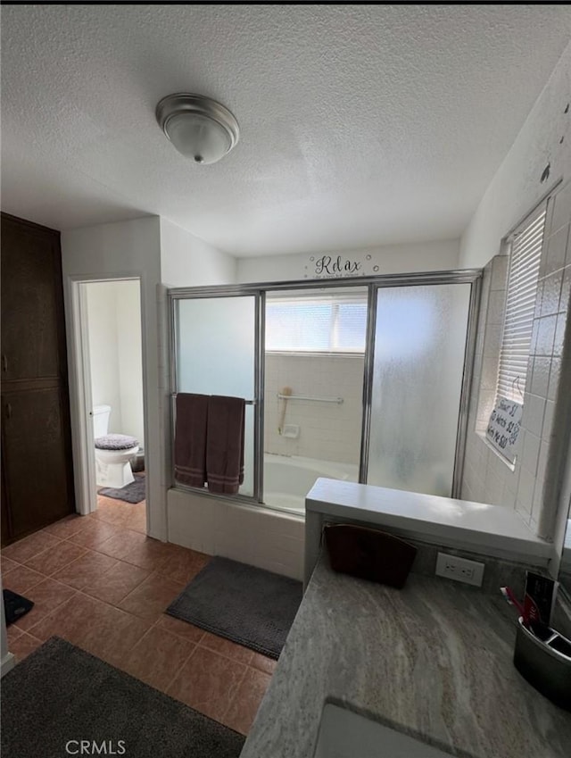 full bath featuring a bathtub, a textured ceiling, an enclosed shower, and tile patterned floors