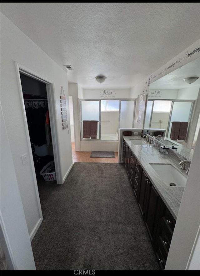 full bathroom featuring double vanity, a wealth of natural light, and a sink