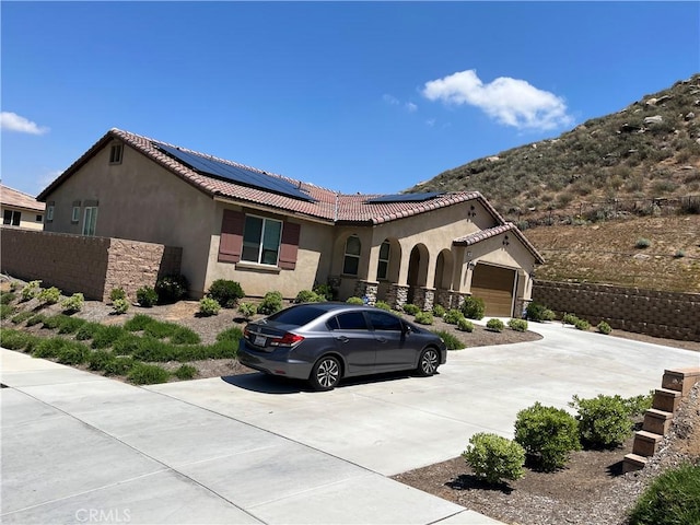 1084 Crownstone Ln, Hemet, CA 92545 - mediterranean / spanish-style home with a garage, stucco siding, concrete driveway, solar panels, and a tiled roof