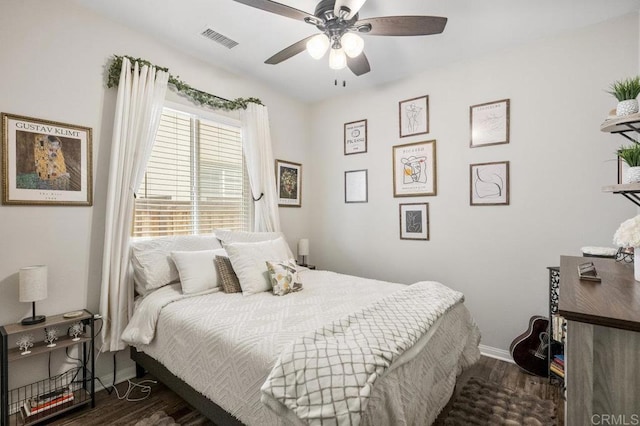 bedroom featuring baseboards, dark wood finished floors, ceiling fan, and visible vents