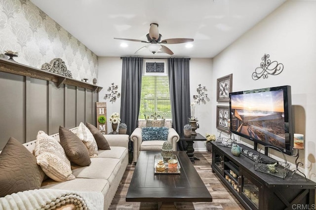 living area with a ceiling fan, wood finished floors, baseboards, wallpapered walls, and recessed lighting