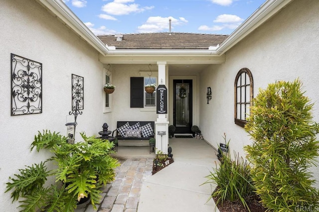 entrance to property with stucco siding and a porch