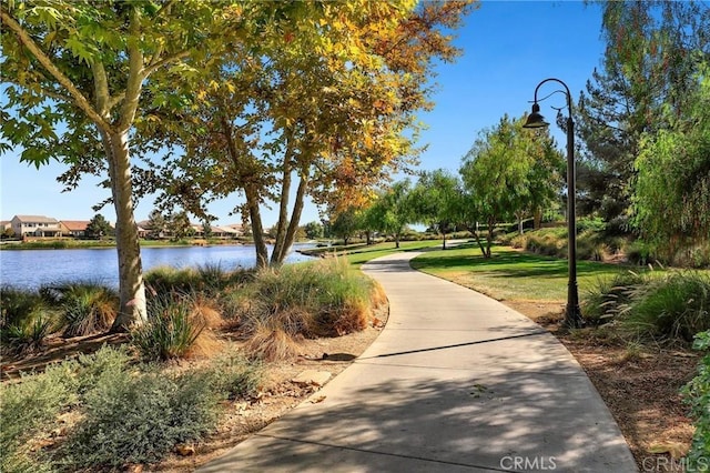 view of community with a lawn and a water view