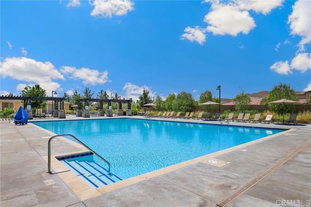 community pool with a pergola, fence, and a patio area