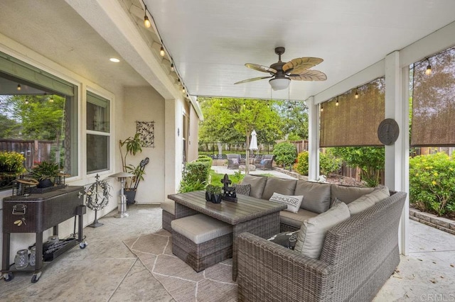 sunroom featuring outdoor dining area, ceiling fan, outdoor lounge area, and stone tile floors