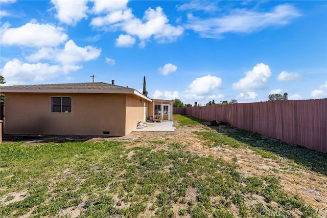 view of yard featuring french doors, a fenced backyard, and a patio area
