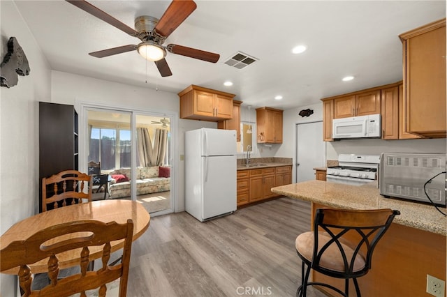 kitchen with white appliances, a ceiling fan, recessed lighting, a peninsula, and visible vents