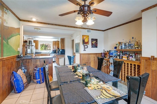 24851 Stem Ave, Lake Forest, CA 92630 - dining space with a wainscoted wall, light tile patterned flooring, wood walls, a ceiling fan, and a dry bar