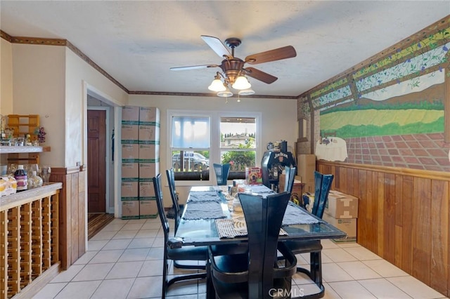 24851 Stem Ave, Lake Forest, CA 92630 - dining space with ceiling fan, wainscoting, light tile patterned flooring, crown molding, and wooden walls