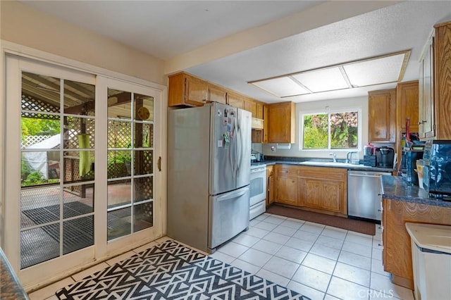 24851 Stem Ave, Lake Forest, CA 92630 - kitchen with stainless steel appliances, brown cabinets, light tile patterned floors, and under cabinet range hood
