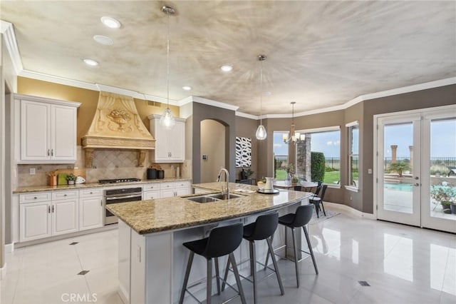 kitchen featuring premium range hood, light tile patterned flooring, a sink, and appliances with stainless steel finishes