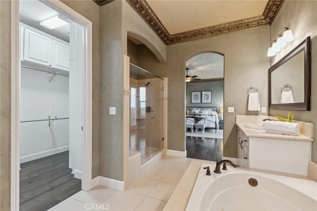 full bath featuring vanity, a ceiling fan, ornamental molding, and a stall shower
