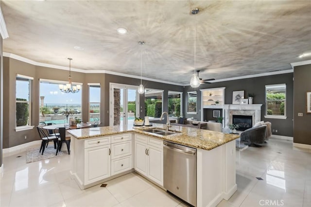 kitchen featuring stainless steel dishwasher, light stone countertops, a sink, and a high end fireplace