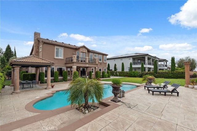pool featuring a lawn, a patio, and a gazebo