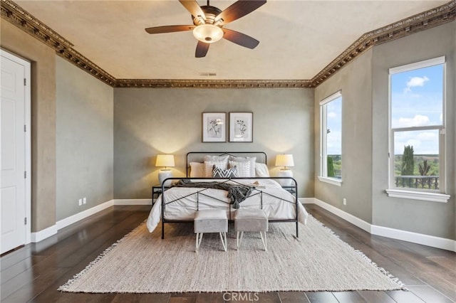 bedroom with baseboards, visible vents, hardwood / wood-style flooring, and ornamental molding