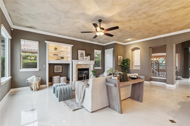 living area with visible vents, ceiling fan, a high end fireplace, and arched walkways
