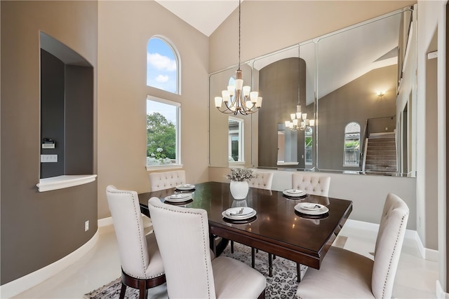 dining room with baseboards, high vaulted ceiling, and an inviting chandelier