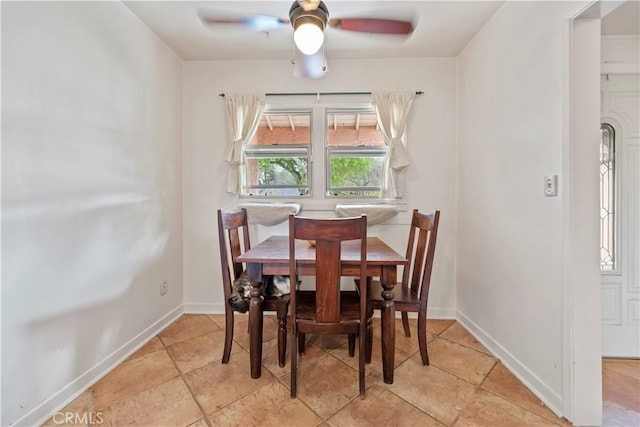 dining space featuring ceiling fan and baseboards
