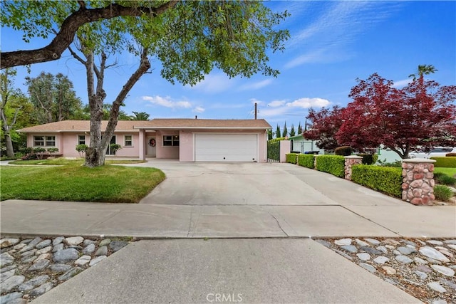 ranch-style home featuring a garage, stucco siding, concrete driveway, and a front yard