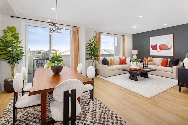 living room featuring an accent wall, light wood-style floors, a chandelier, wallpapered walls, and recessed lighting