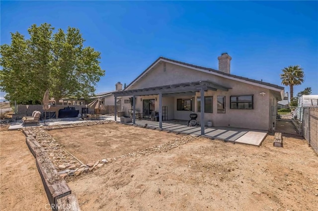 26323 Corona Dr, Helendale, CA 92342 - rear view of house with stucco siding, a patio area, fence, and a chimney