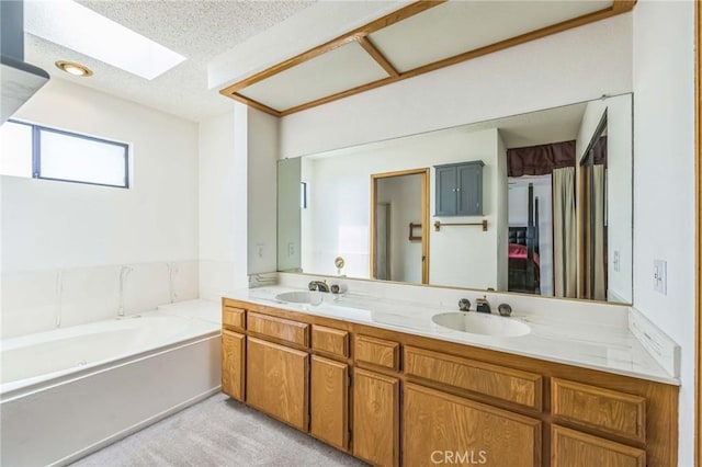 26323 Corona Dr, Helendale, CA 92342 - bathroom with double vanity, a skylight, a sink, and a garden tub
