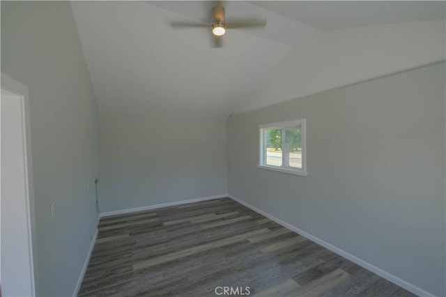 unfurnished room with wood finished floors, lofted ceiling, and baseboards