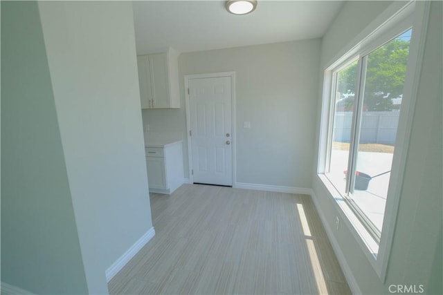 interior space featuring light wood-style flooring and baseboards