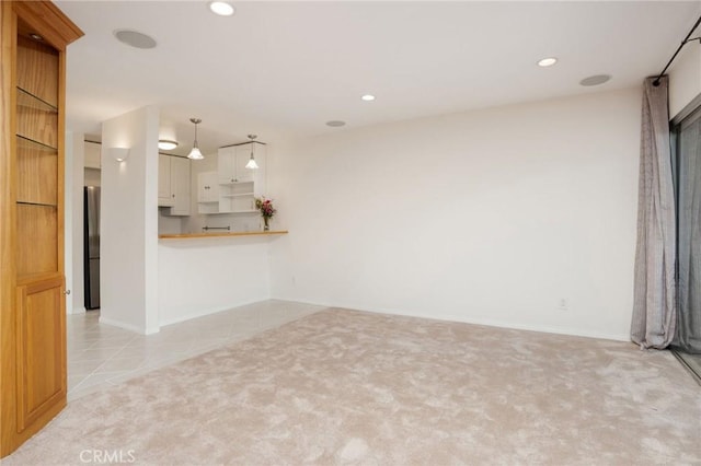 unfurnished living room featuring baseboards, recessed lighting, and light colored carpet