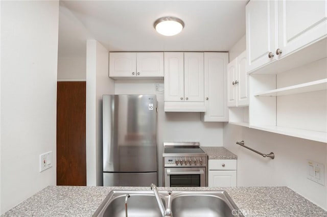 kitchen with appliances with stainless steel finishes, a sink, light countertops, white cabinets, and under cabinet range hood