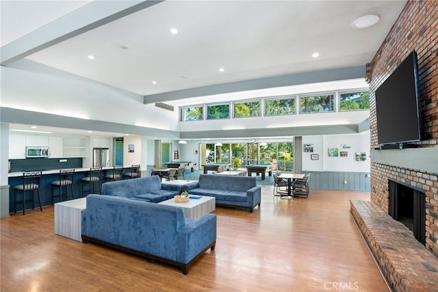 living room with recessed lighting, light wood-style flooring, wainscoting, and a fireplace
