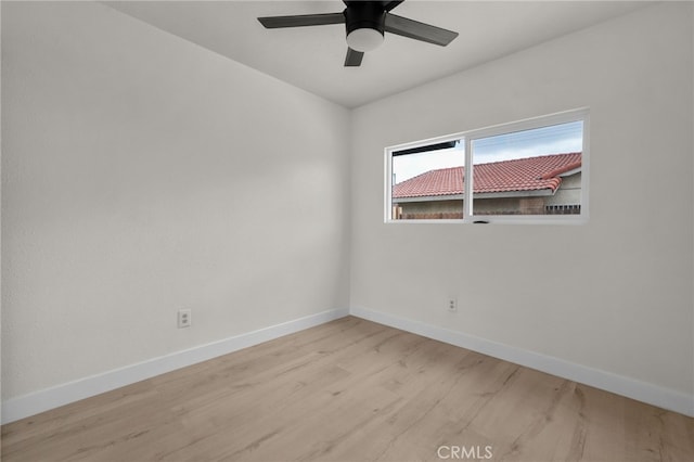 empty room with baseboards, ceiling fan, and light wood-style floors