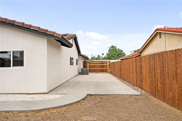 view of home's exterior with a tile roof, stucco siding, a fenced backyard, and a patio area