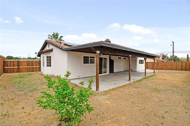 rear view of house featuring a lawn, a patio area, solar panels, and a fenced backyard