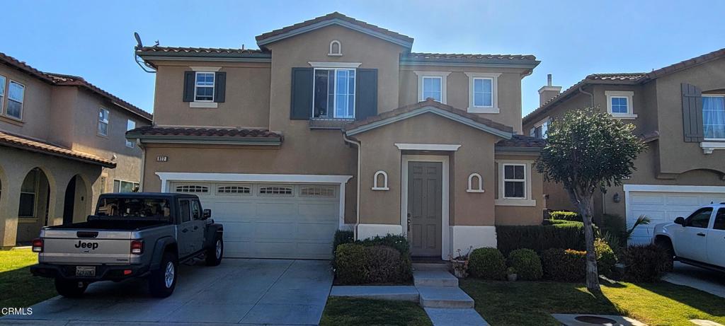 view of front of property with a tiled roof, a garage, stucco siding, and driveway