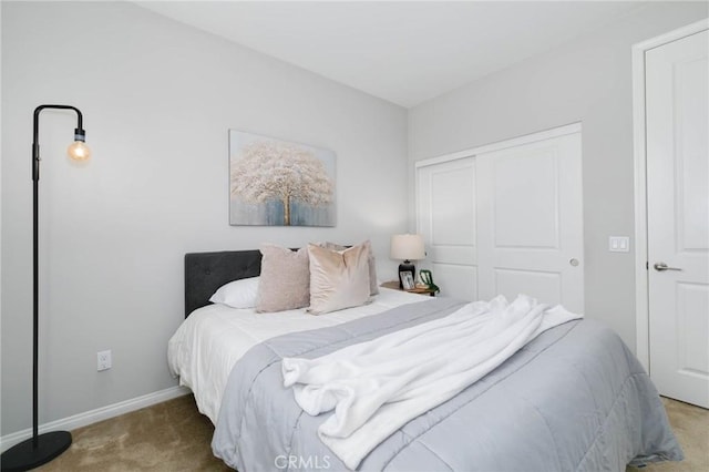 bedroom with baseboards, a closet, and carpet flooring