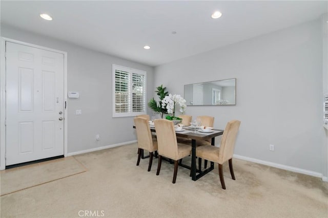 dining space with baseboards, recessed lighting, and light carpet
