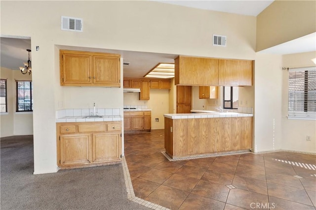 15631 Via Cartagena St, Hesperia, CA 92345 - kitchen with a towering ceiling, visible vents, a peninsula, and tile countertops