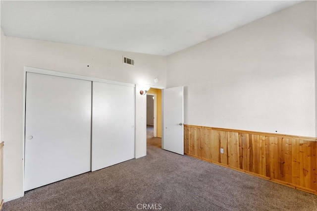 15631 Via Cartagena St, Hesperia, CA 92345 - unfurnished bedroom with a closet, carpet, a wainscoted wall, visible vents, and wooden walls