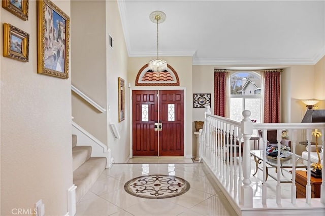 tiled entryway featuring baseboards, visible vents, and ornamental molding