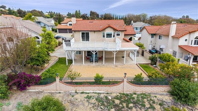 back of house featuring a deck, a patio, a fenced backyard, stucco siding, and stairs