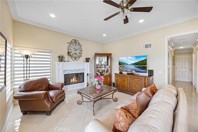 living area with a ceiling fan, visible vents, light tile patterned floors, ornamental molding, and a premium fireplace