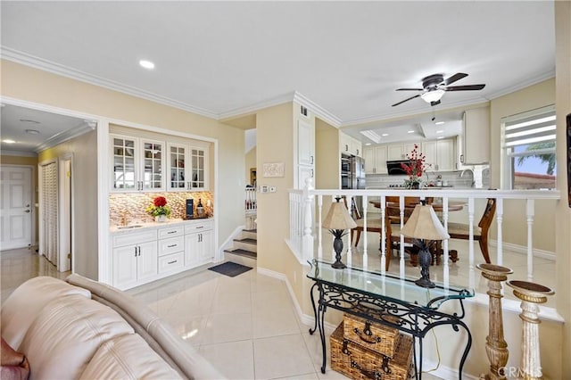 living area with crown molding, baseboards, ceiling fan, stairway, and recessed lighting