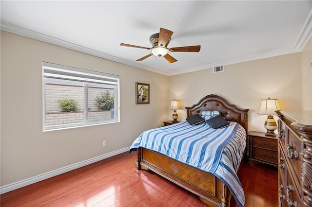 bedroom with crown molding, visible vents, and wood finished floors