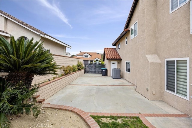 view of patio / terrace with central AC, fence, and a gate