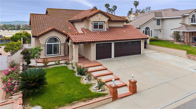 mediterranean / spanish-style house with concrete driveway, a tile roof, and stucco siding